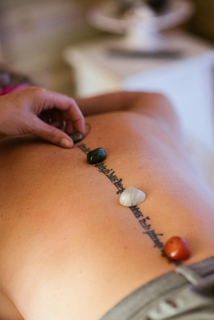 Massage therapy session with healing stones on a woman's back for relaxation and stress relief.