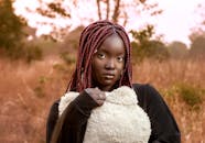 Stylish portrait of a young woman with dyed braids outdoors in Lapai, Nigeria.